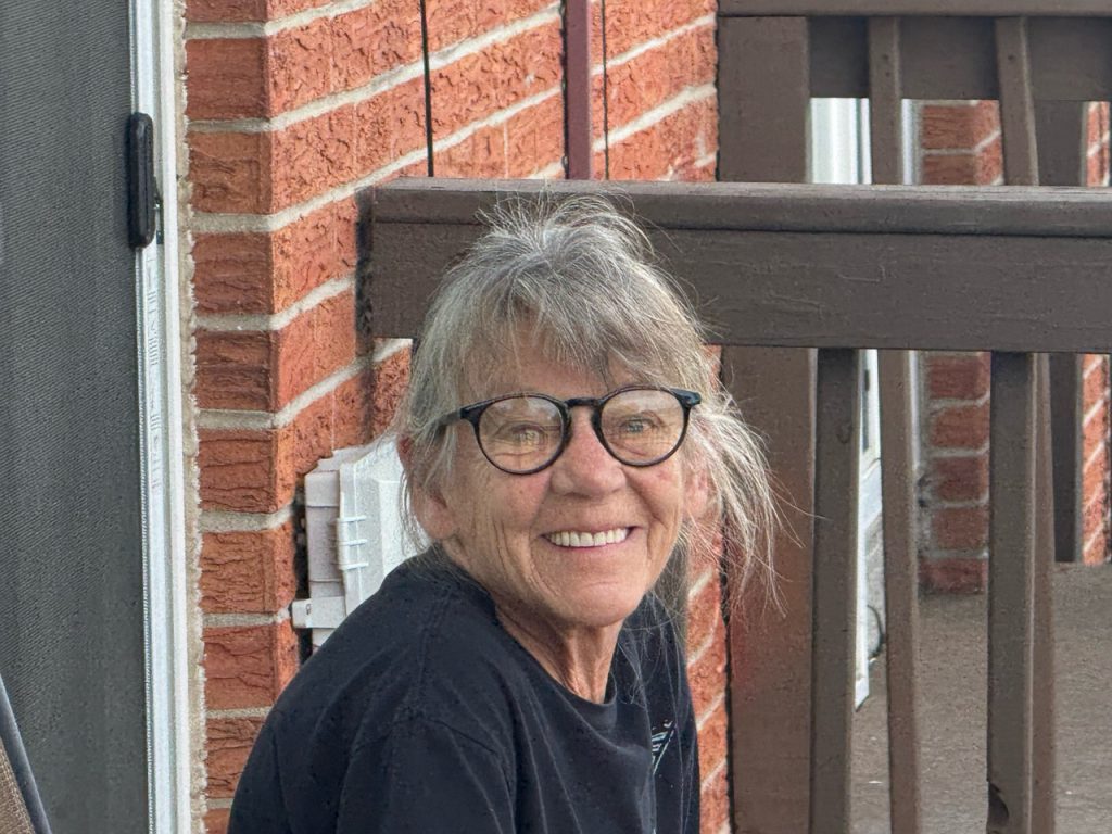 A smiling neighbor sitting on the porch.